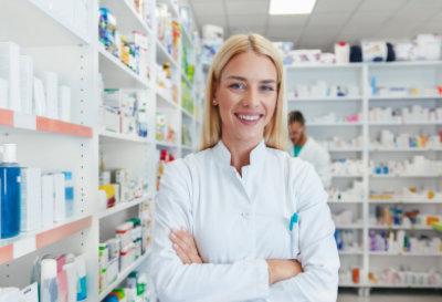 Female pharmacist smiling while crossing her arms