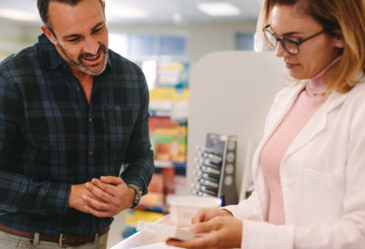 Female pharmacist showing something to the customer